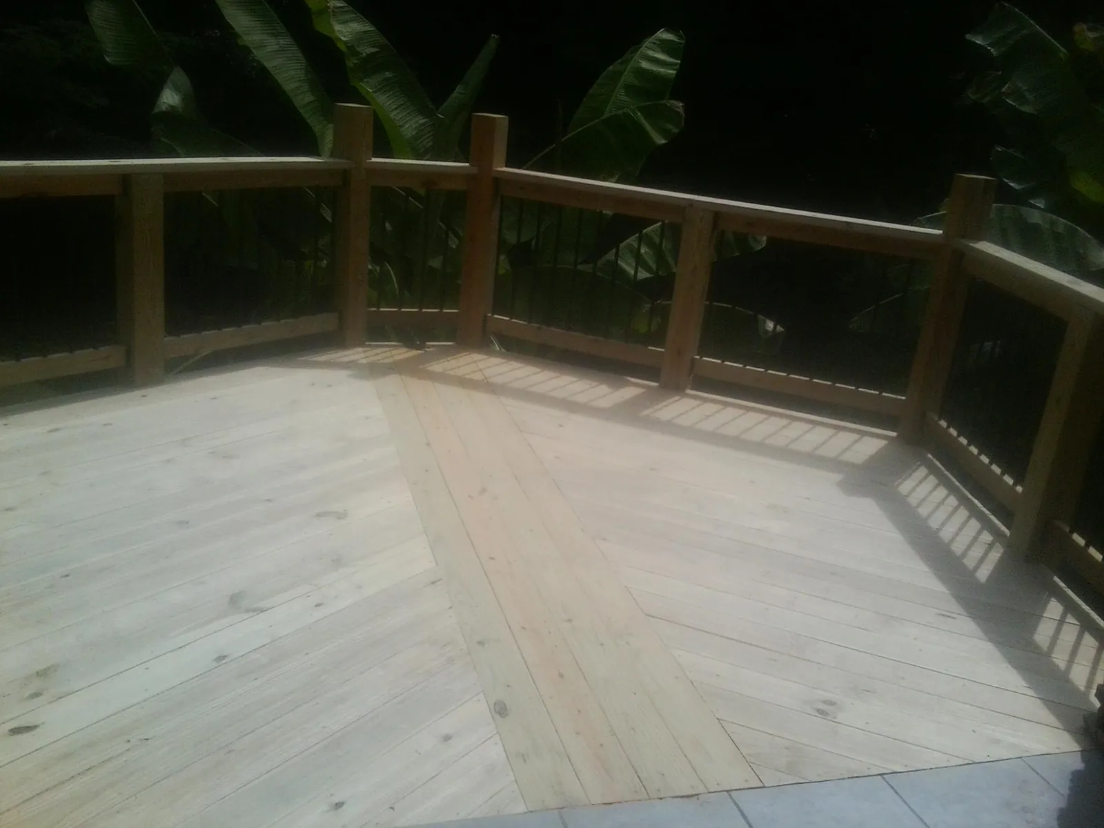 New wood deck and railing built off the back of a home in Marston