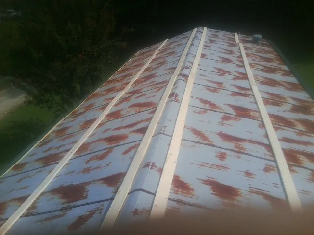 Rusted metal roof panels with new wood purlins before replacement — Storm Damage Roof Repair in Marston by Roofing Brothers