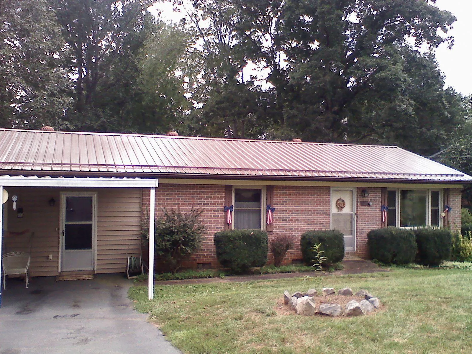 Bronze metal roof and carport on a brick ranch home — Roof Repair work by our crew in Marston